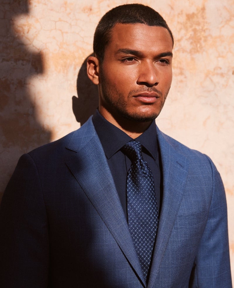Paulo Lopes Lucio wears a blue suit, dark shirt and tonal patterned tie in a close portrait.