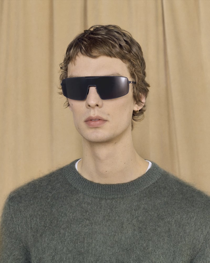 Leon Dame wears RIMOWA x MYKITA Visor MR008 shield sunglasses with a fuzzy sweater.