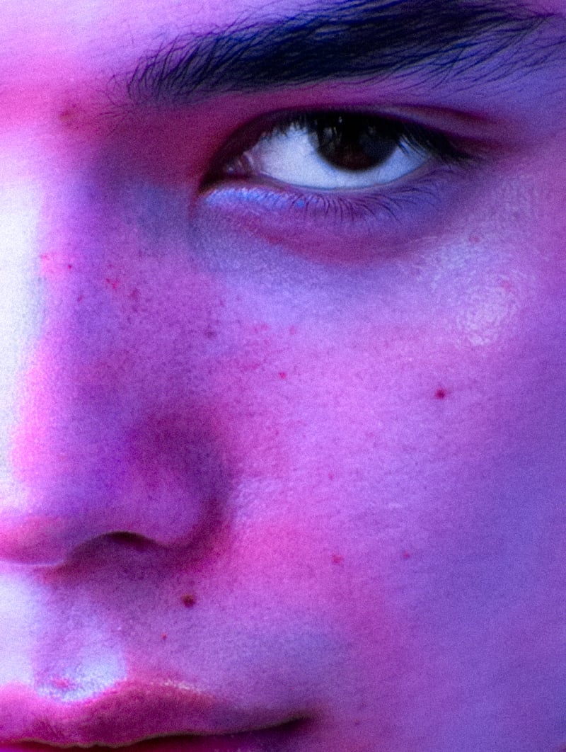 Sasha Profatilov appears in a close-up portrait under purple and pink light.