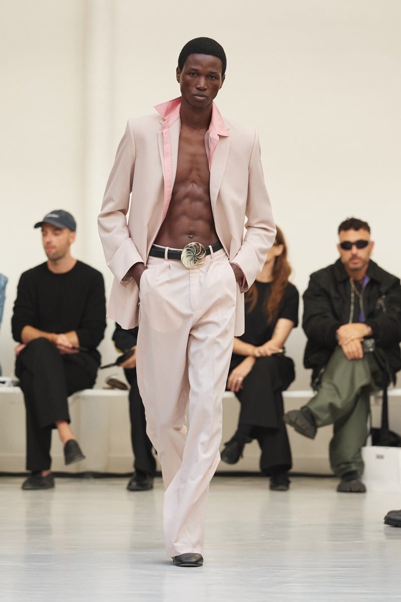 Model wearing a pale pink suit, open shirt and Borjgali belt buckle at Situationist spring-summer 2027.