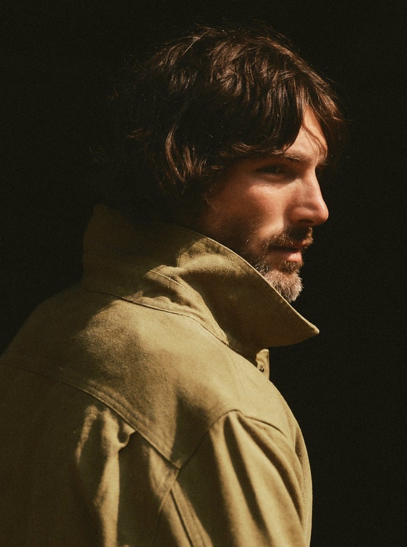 Close-up of a model wearing an olive overshirt with the collar turned up. Taylor Stitch winter 2026 collection.