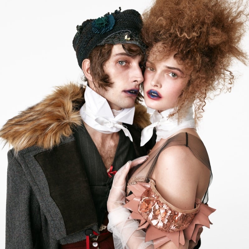 Close-up of Thomas Riguelle in a knit cap with a faux fur-trimmed coat beside Lulu Tenney in a metallic lace bodice and white neck scarf