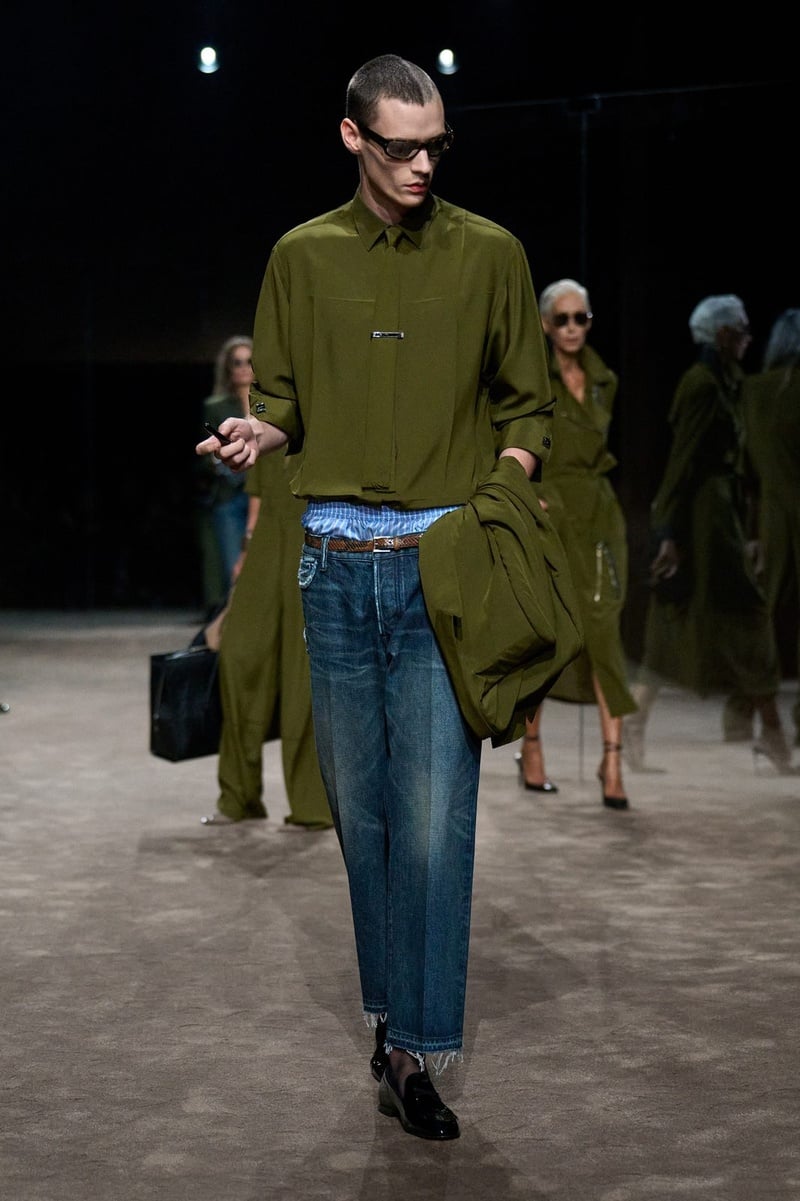 A model wears olive sweater over a pale blue shirt with jeans on the Tom Ford spring-summer 2027 runway.