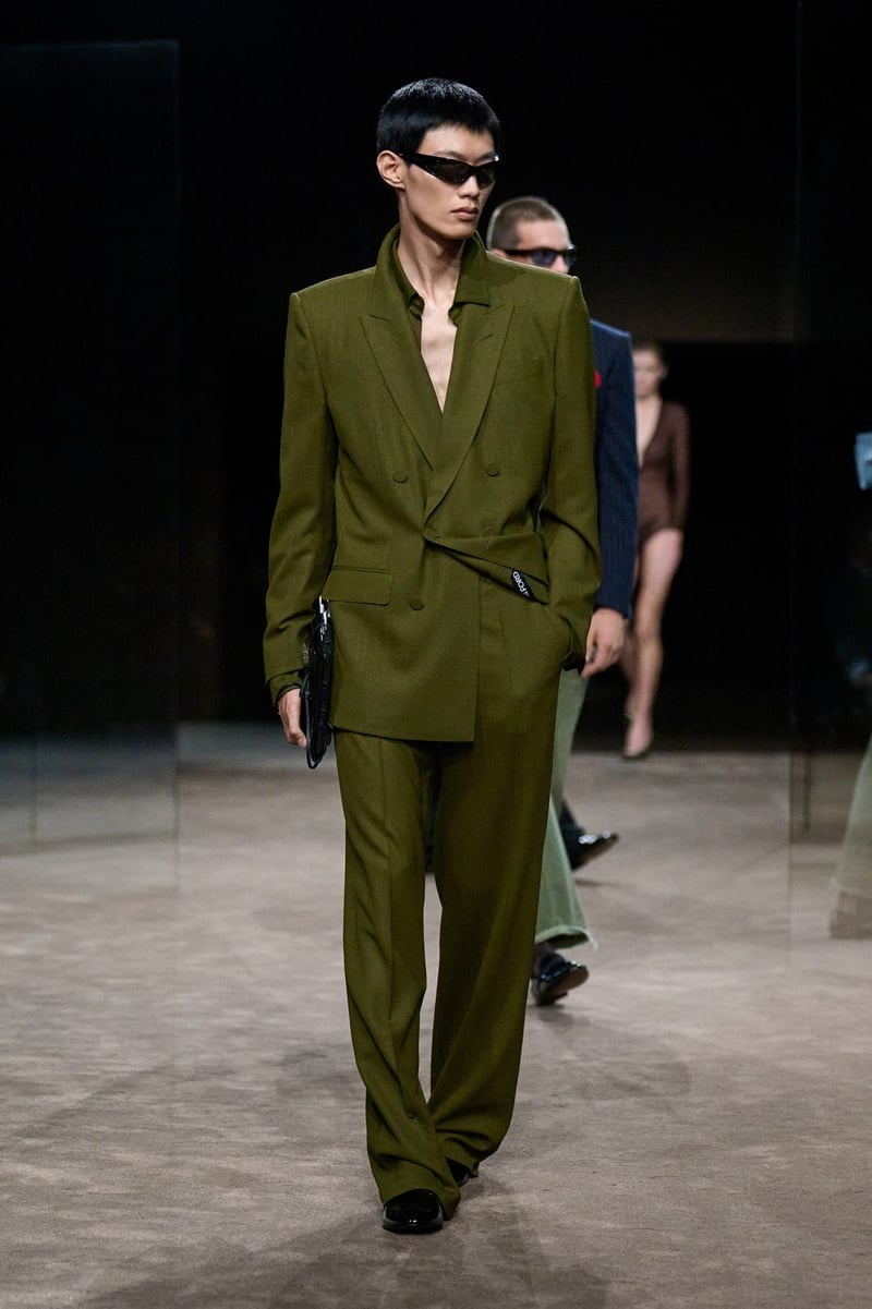 A model wears olive suit with an open shirt and sunglasses on the Tom Ford spring-summer 2027 runway.