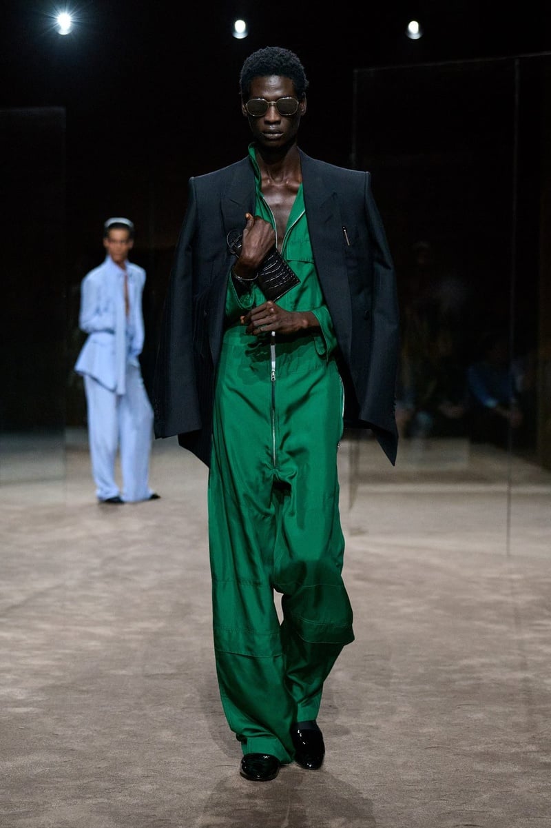 A model wears green shirt and trousers with a dark jacket on the Tom Ford spring-summer 2027 runway.