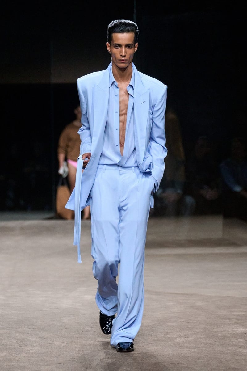 A model wears pale blue suit with an open shirt and long hanging ties on the Tom Ford spring-summer 2027 runway.