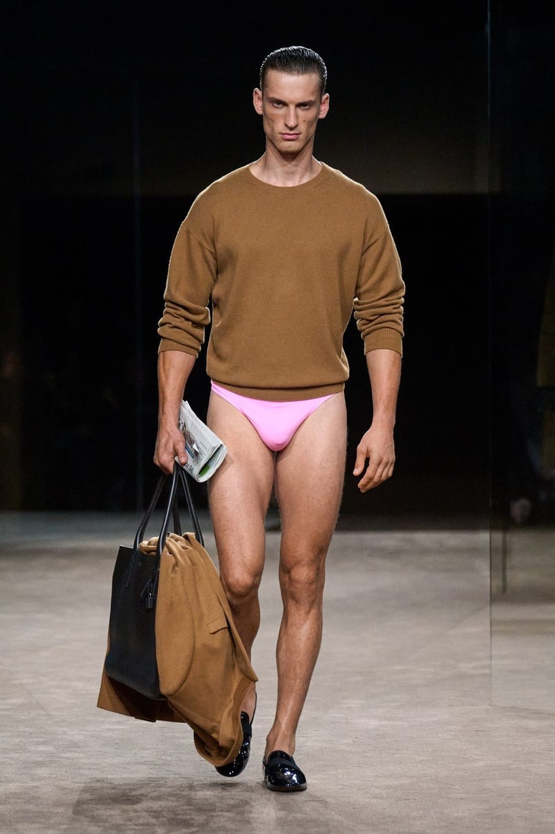 A model wears brown crewneck sweater with pink briefs and a large bag on the Tom Ford spring-summer 2027 runway.