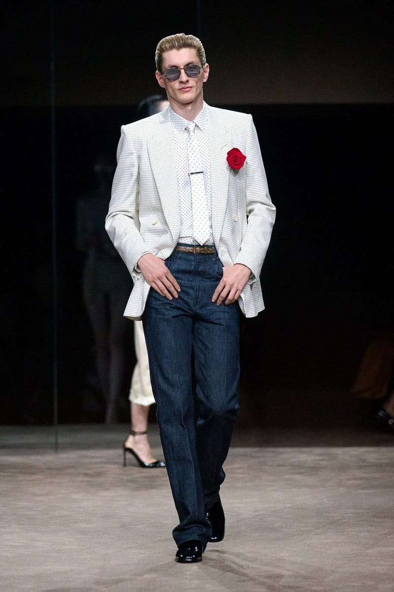 A model wears white jacket with a red rose and dark trousers on the Tom Ford spring-summer 2027 runway.