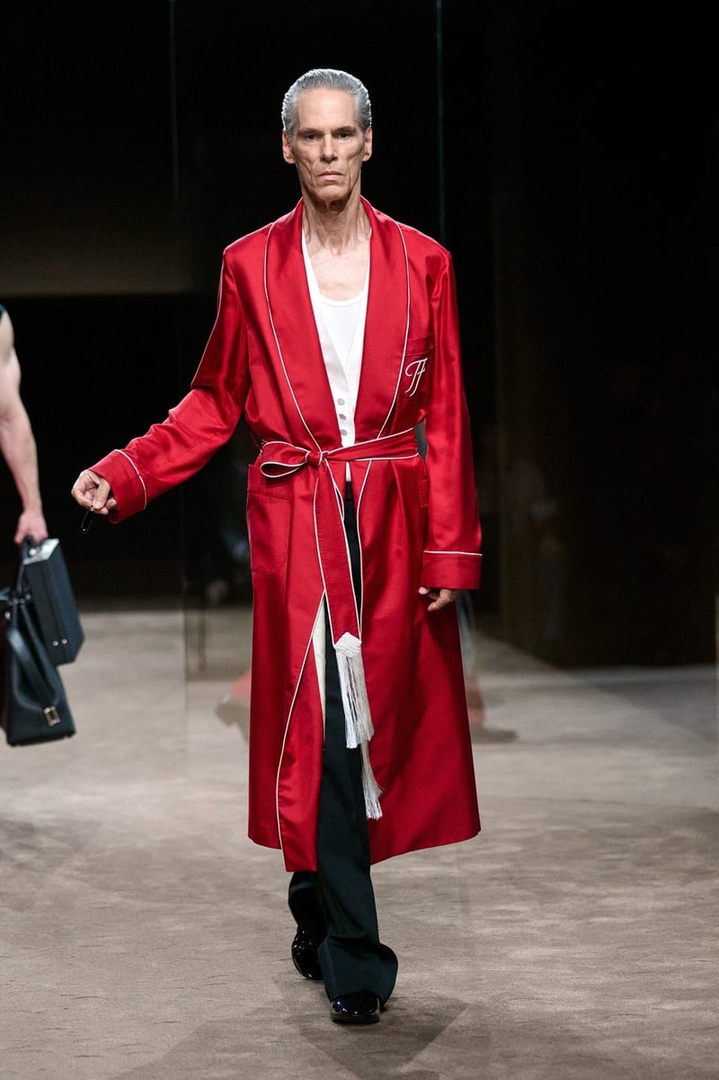 A model wears red belted robe over dark trousers on the Tom Ford spring-summer 2027 runway.