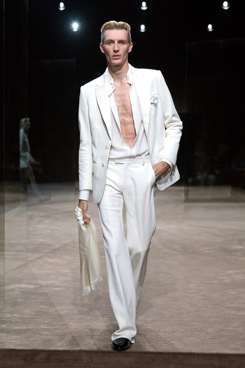 A model wears white suit over a deeply open shirt on the Tom Ford spring-summer 2027 runway.