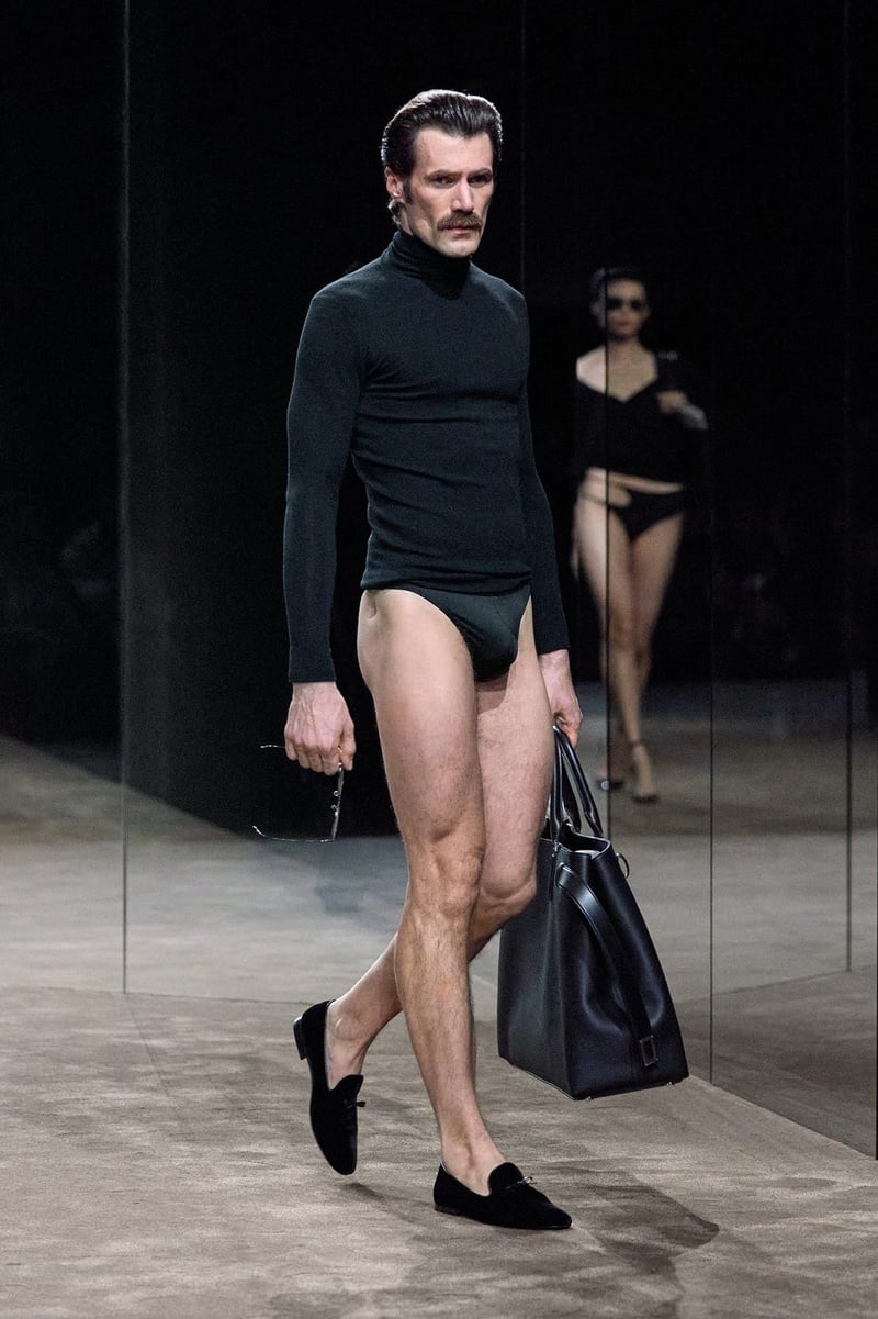 A model wears black turtleneck with high-cut black briefs, carrying a bag on the Tom Ford spring-summer 2027 runway.