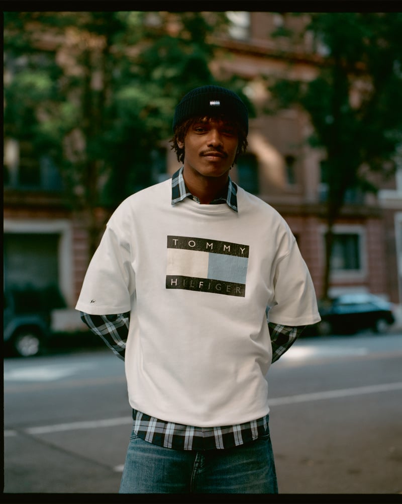 Nile Winchester wears a white Tommy Hilfiger x FRGMT logo T-shirt over a plaid shirt.