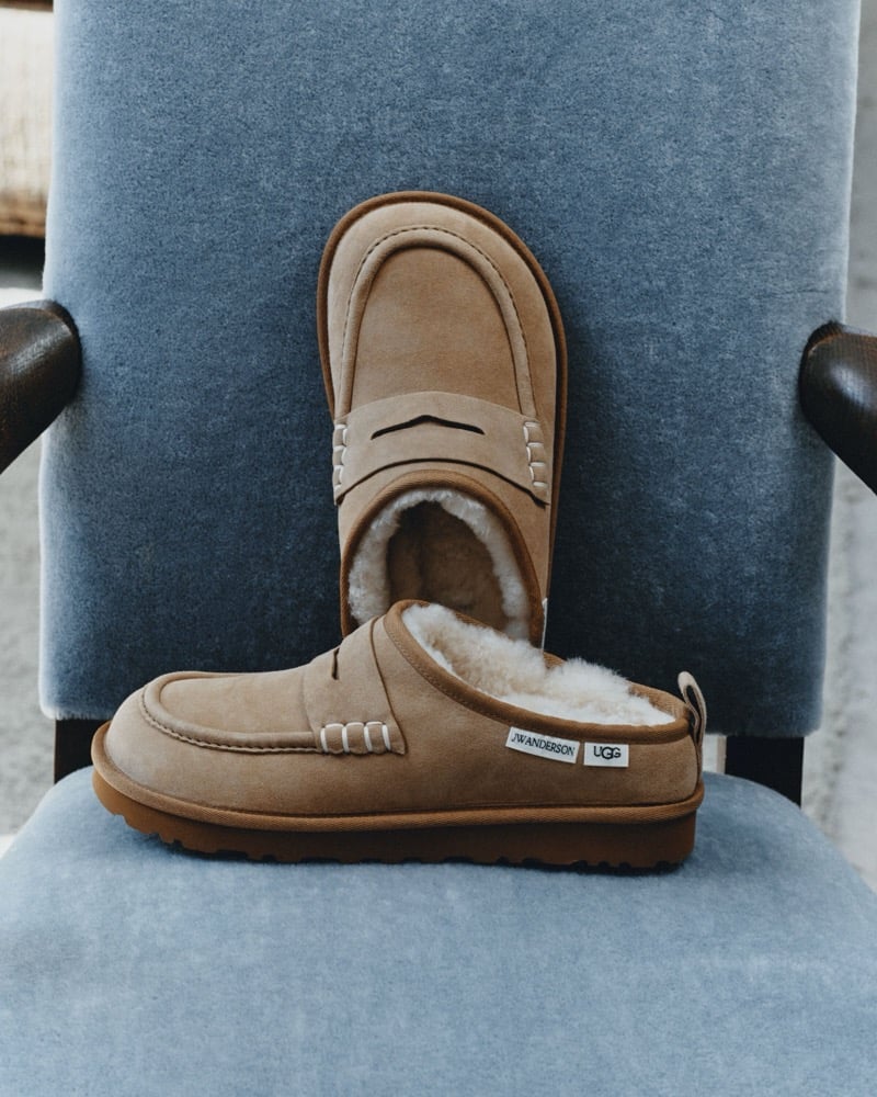 Chestnut UGG x JW Anderson loafers displayed on a blue chair.
