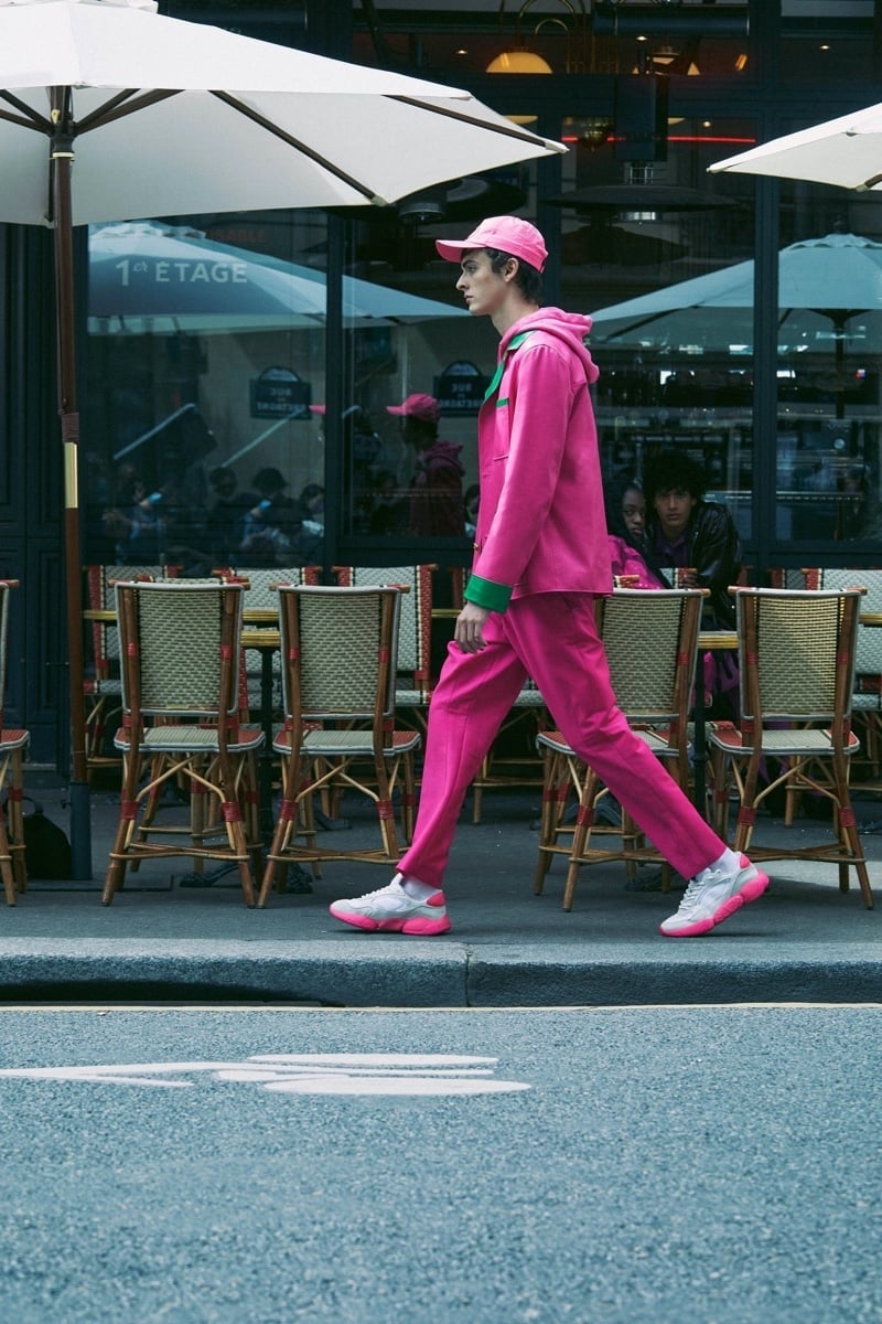 Valentino’s resort 2022 styling places sculpted sneakers beneath a pink tailored outfit layered with a hoodie.