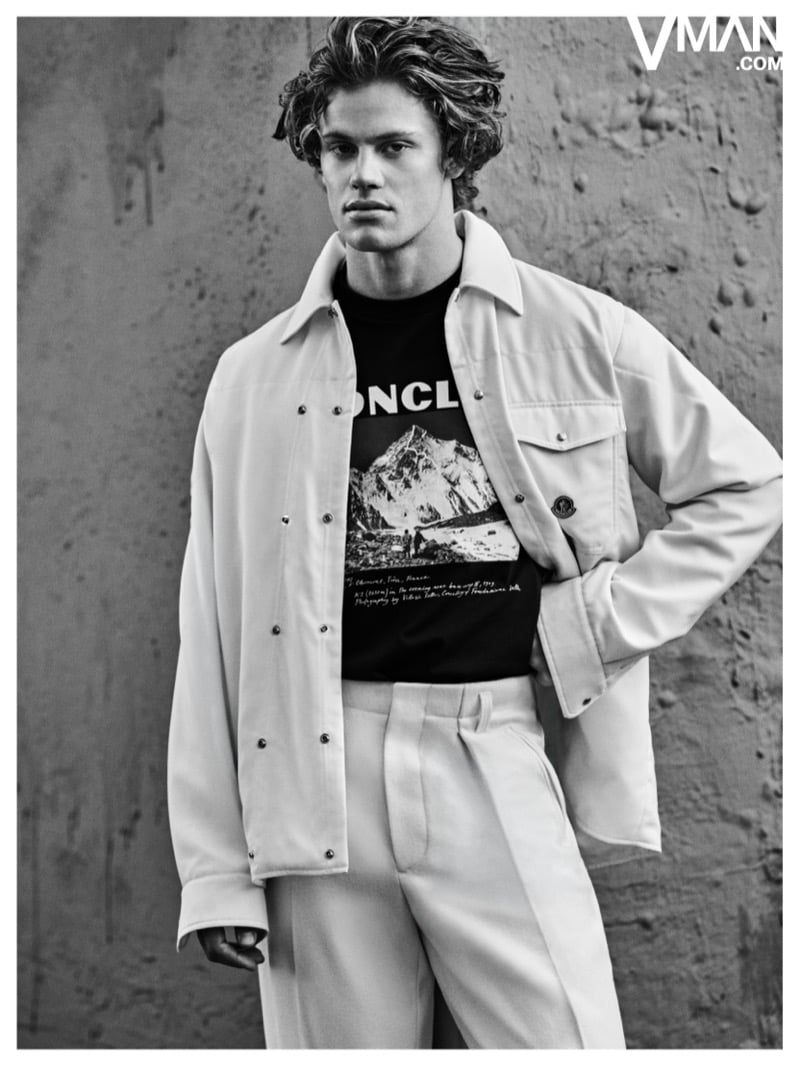Lucas Pinheiro Braathen wears a light-colored Moncler jacket and trousers with a graphic T-shirt in black and white.