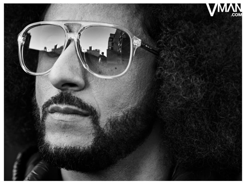 Colin Kaepernick wears aviator sunglasses in a black-and-white close-up.