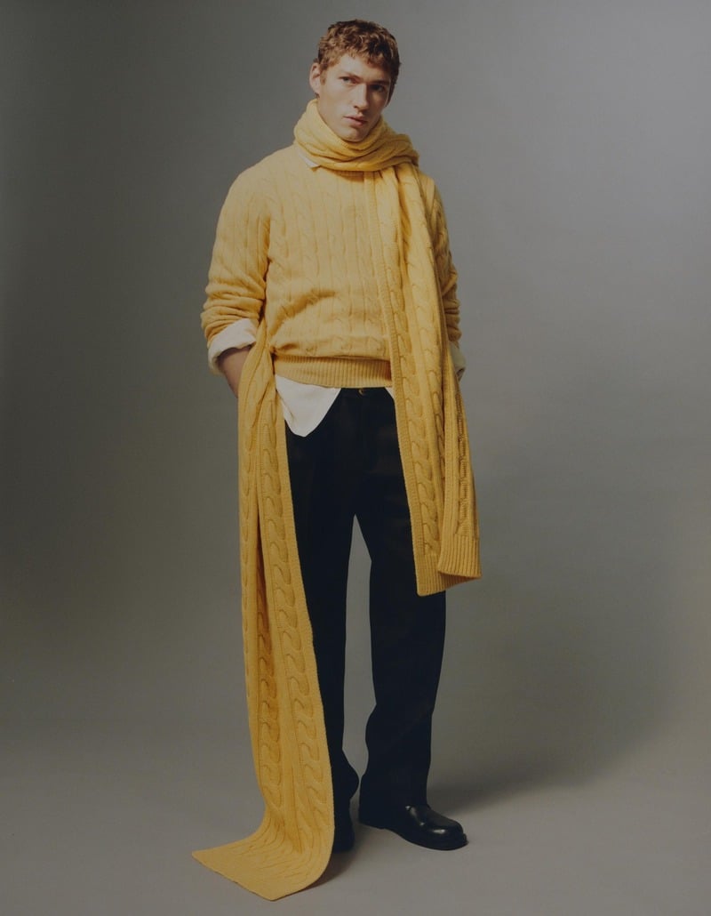 Valentin Humbroich wears a yellow cable-knit sweater and floor-length matching scarf with dark trousers.