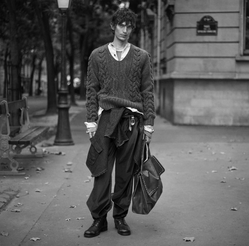 Cirillo wears a cable-knit sweater over a shirt with loose trousers and a layer tied at his waist for Zara Studio's fall-winter 2026 campaign