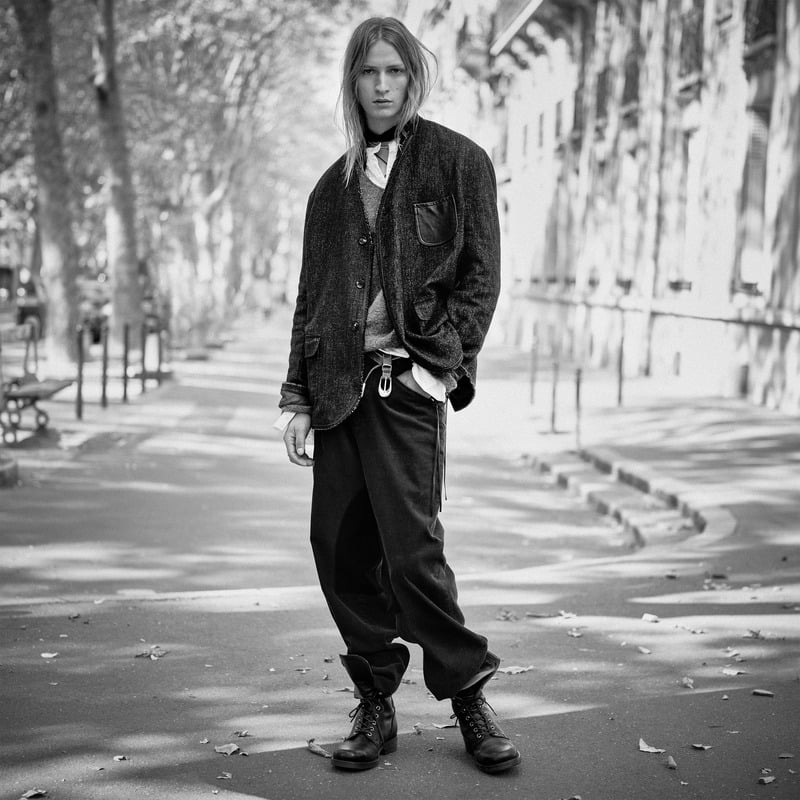 Jesse Rinderknecht wears a textured jacket over a layered shirt and knitwear with loose trousers and boots for Zara Studio's fall-winter 2026 campaign