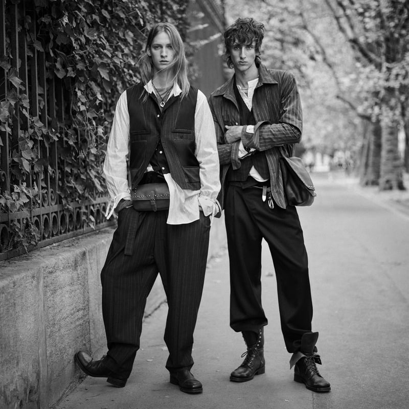 Jesse Rinderknecht and Luke Boyer wear layered waistcoats and shirting with loose trousers beside an ivy-covered fence for Zara Studio's fall-winter 2026 campaign