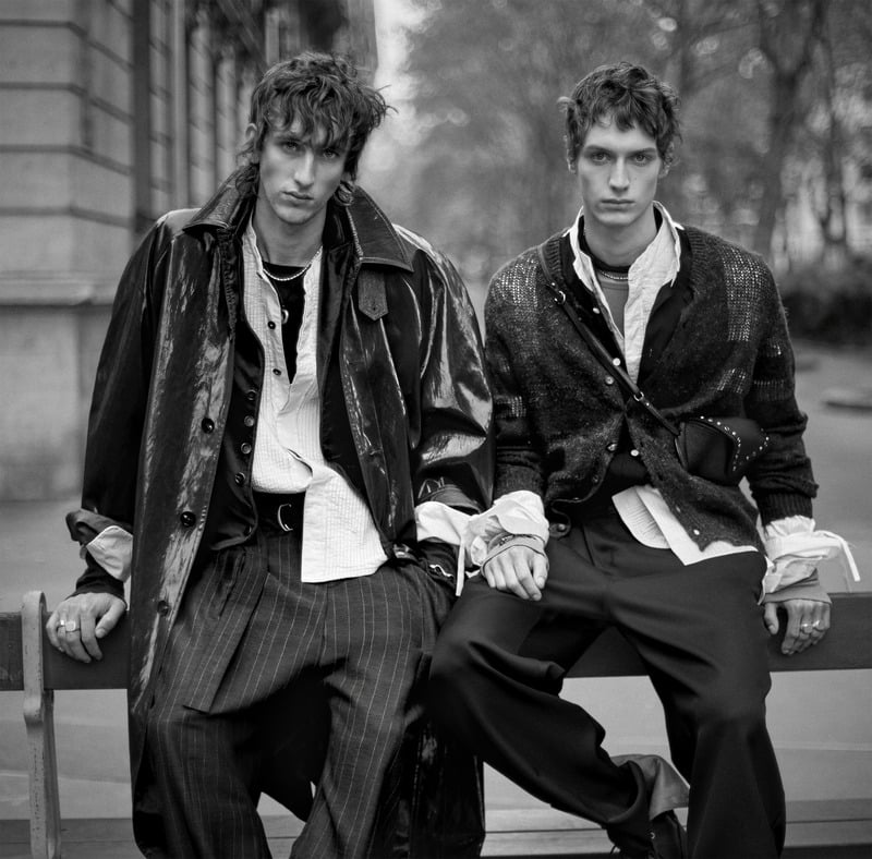 Luke Boyer and Leonard Kipker sit on a bench wearing layered shirts with leather and knit outerwear for Zara Studio's fall-winter 2026 campaign