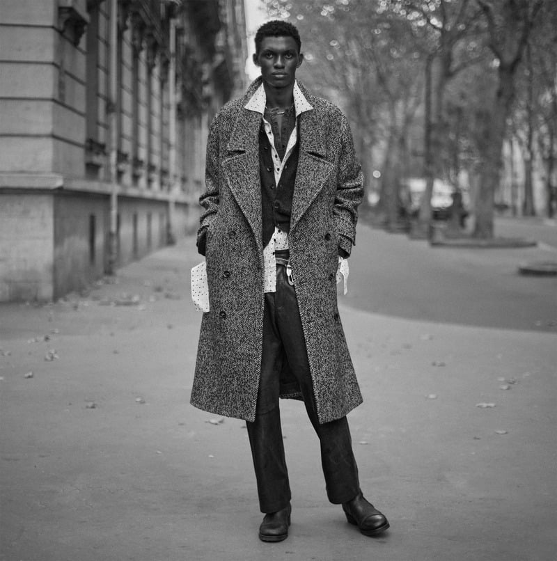 Rouna Obigba wears a textured overcoat over a jacket and open shirt with tailored trousers for Zara Studio's fall-winter 2026 campaign